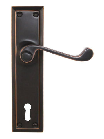 Bronze door handle with keyhole on a white background
