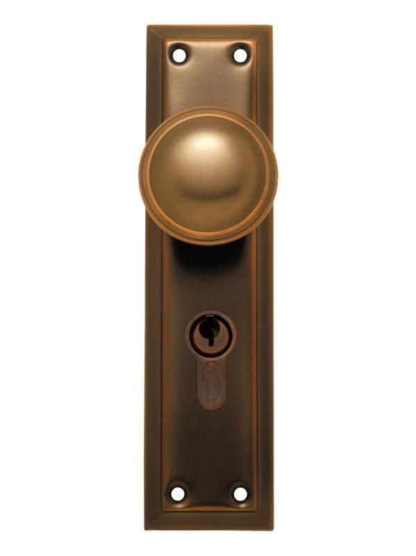 Bronze door handle with keyhole on a white background