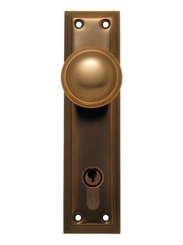 Bronze door handle with keyhole on a white background