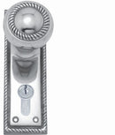 Polished chrome door handle with keyhole on a white background