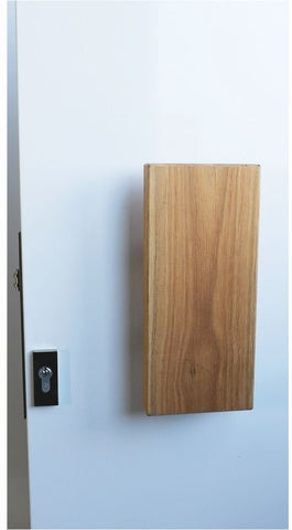 Wooden block attached to a white wall with a light switch.