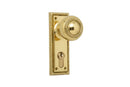 Polished brass door handle and lockset on a white background