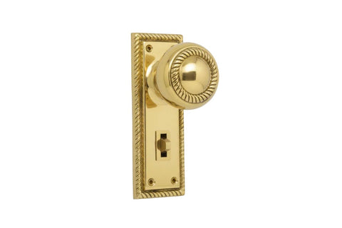Polished brass door handle and plate on a white background