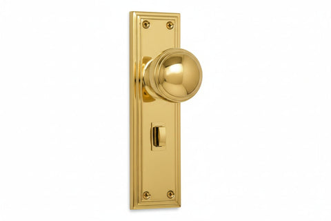 Gold door handle and plate on a white background