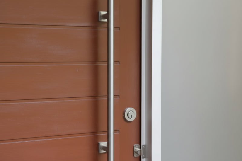 Wooden door with a metallic handle on a modern building exterior.