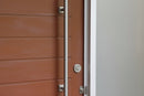 Wooden door with a metallic handle on a modern building exterior.