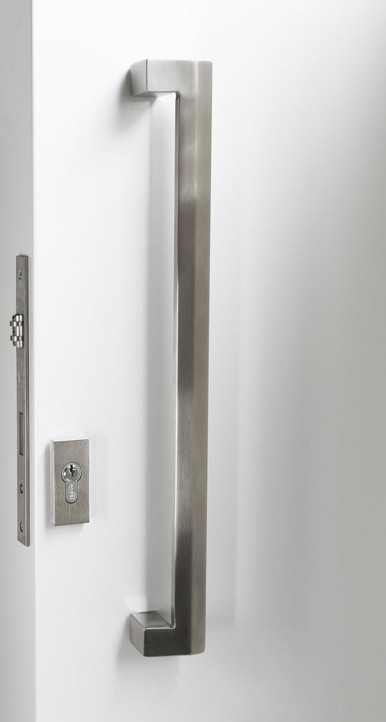 Stainless steel door handle on a white door with a metallic lock.