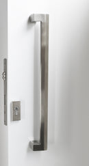 Stainless steel door handle on a white door with a metallic lock.