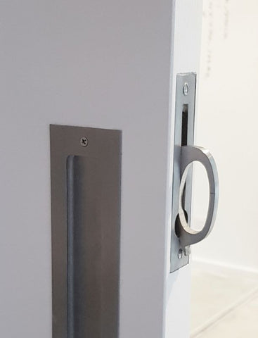 Close-up of a door handle and lock mechanism on a white door.