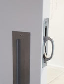 Close-up of a door handle and lock mechanism on a white door.