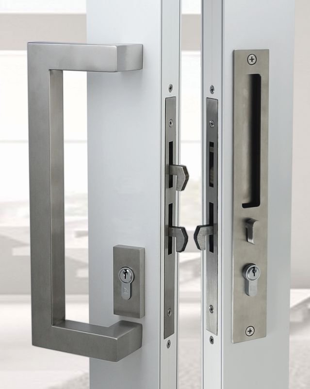 Close-up of a modern door handle and lock mechanism on a glass door.