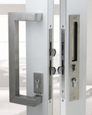 Close-up of a modern door handle and lock mechanism on a glass door.