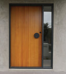 Wooden door with a black handle on a concrete wall