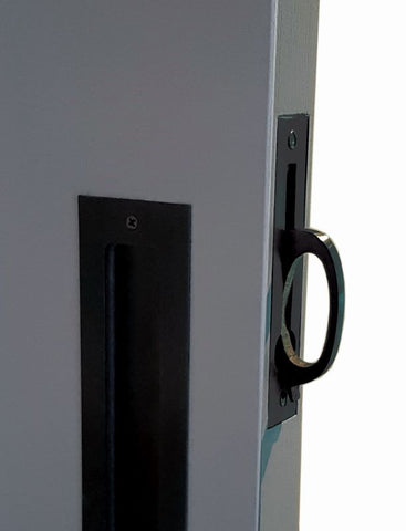 Close-up of a door handle and lock mechanism on a gray door.