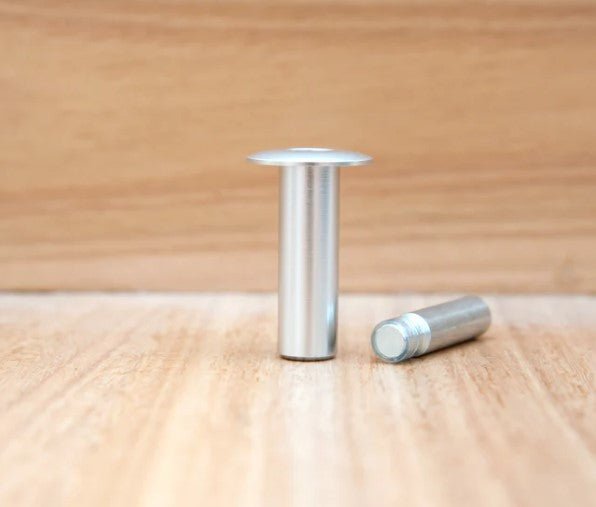 Two metallic cylindrical objects on a wooden surface