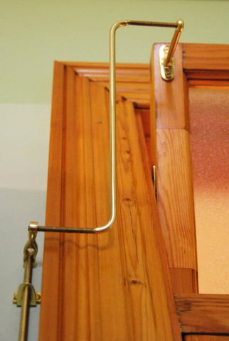 Wooden easel with a gold-colored U-shaped stand on a light green background