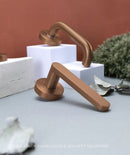 Copper door handles on a neutral background with 'assa abloy' branding.