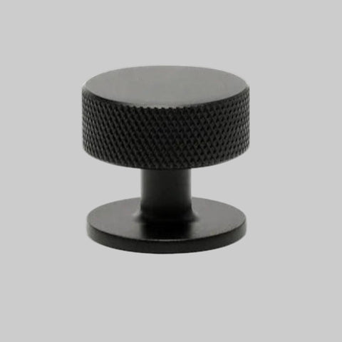 Black textured knob on a white background