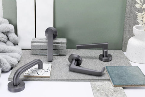 Set of gray door handles on a surface with a neutral background